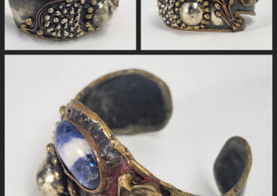 Ornate metal cuff bracelet with blue stone