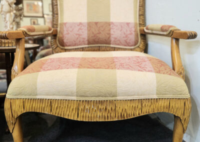 Antique upholstered armchair with decorative fringe