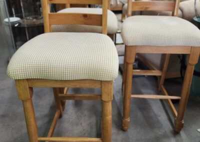 Two wooden ladder-back chairs with upholstered seats