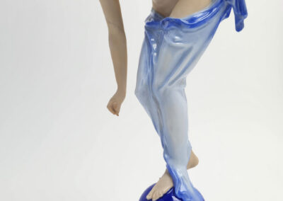 Porcelain figurine of woman balancing on blue ball