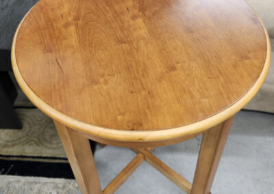 Round wooden side table with cross-braced legs