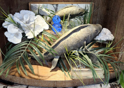 Two carved fish display with plants