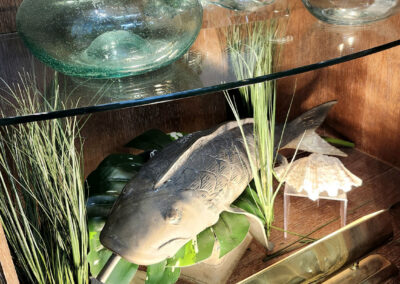 Decorative fish sculpture with glass vases and greenery