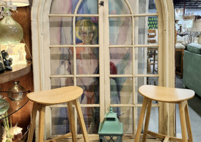 Two stools and lantern beside arched window