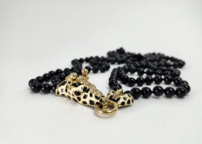 Gold panther head pendant on black beaded necklace