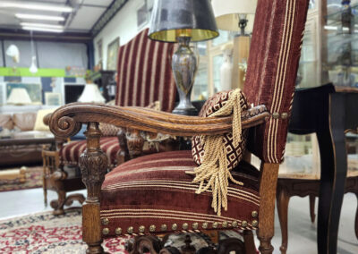 Antique carved wooden upholstered armchair on rug
