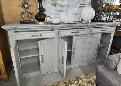 Light gray distressed sideboard with open cabinet doors